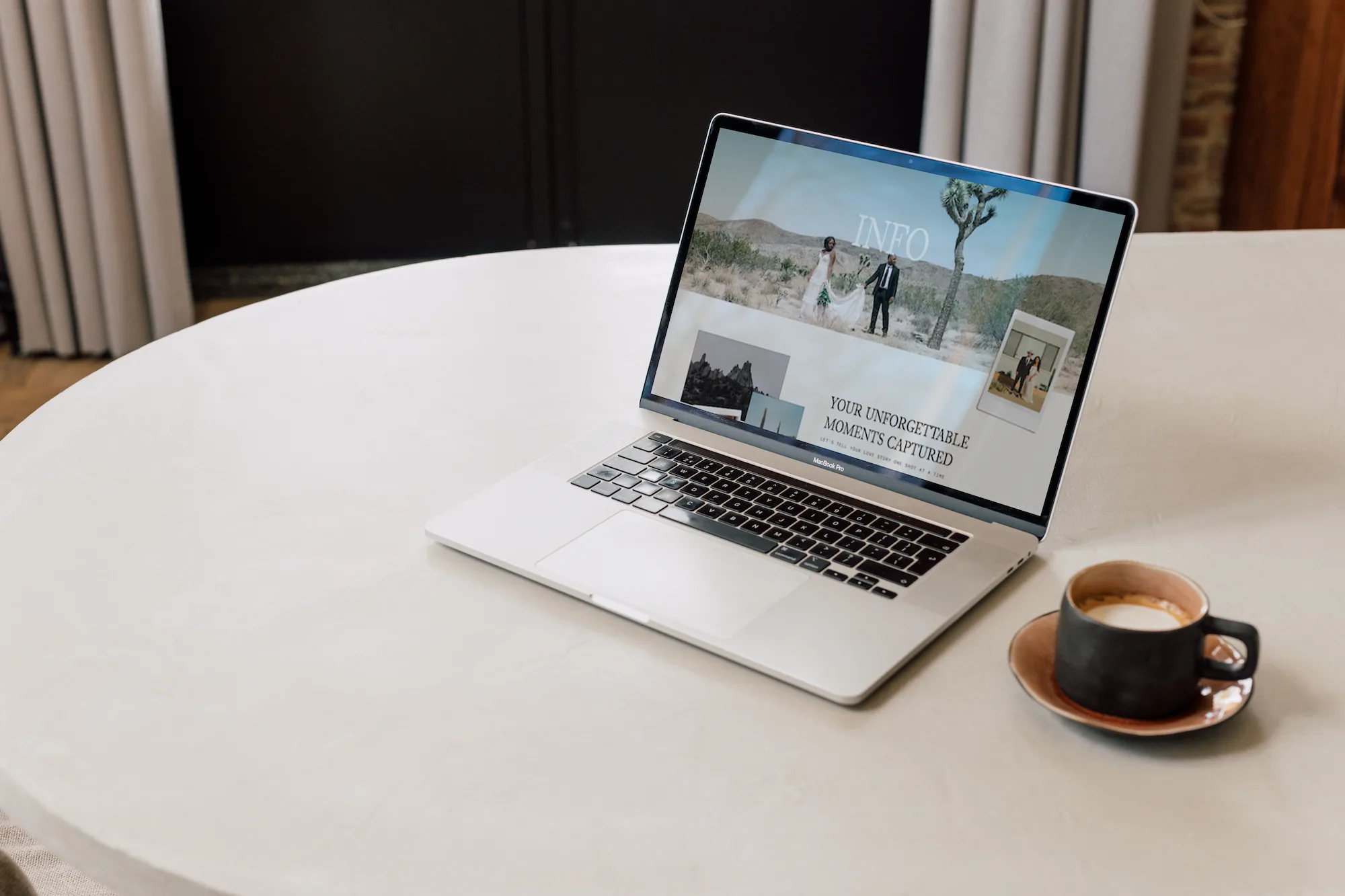 Laptop on a white table beside a cup of coffee.